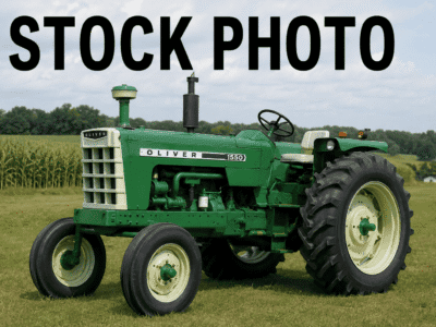 Oliver 1550 tractor with green body and large rear tires on a farm field.