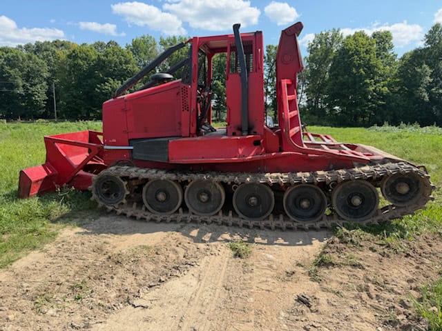 KMC 1000AG track skidder with red body and rubber tracks on grassy field.