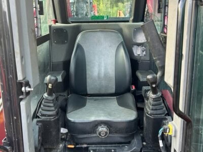 Cabin interior of 2024 YANMAR TL100VS compact tractor with controls and seat.