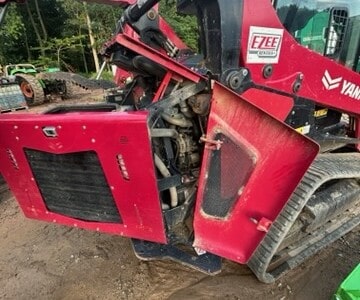 Red Yanmar TL100VS compact track loader with cab and rubber tracks, front attachment, outdoor setting.