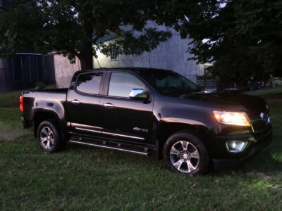 2018 Chevrolet Colorado Z71 black pickup truck with chrome accents parked on grass.