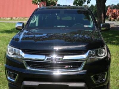 2018 Chevrolet Colorado Z71 black pickup truck with chrome accents and off-road tires.