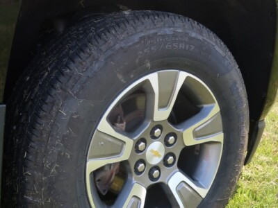 Close-up of 2018 Chevrolet Colorado Z71 tire and wheel on grassy surface.