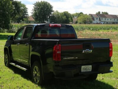 2018 Chevrolet Colorado Z71 black pickup truck parked on grass under trees.