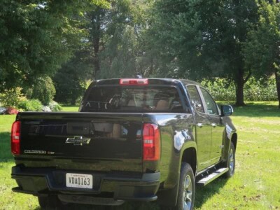 2018 Chevrolet Colorado Z71 black pickup truck in a grassy park with trees.