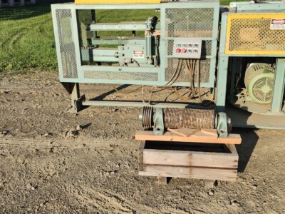 Industrial log birsmouth machine with control panel and hydraulic system.
