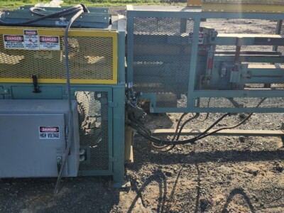 Industrial log Birsdmouth machine with safety guards and hydraulic components.