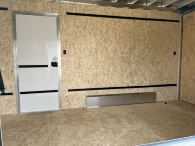 Enclosed aluminum concession trailer interior with plywood walls and floor.