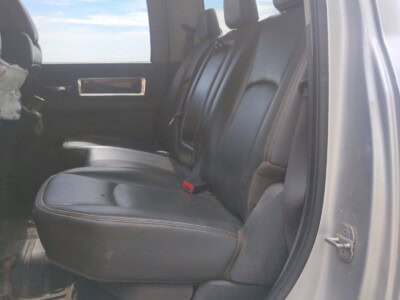 Black leather rear seats inside a pickup truck with three headrests and a window view.