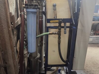 Industrial water filtration system with pipes and filters in a workshop setting.