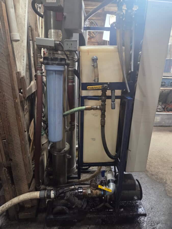 Industrial water filtration system with pipes and filters in a workshop setting.