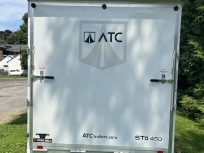 ATC enclosed aluminum concession trailer with logo and website, ST0 450 model, on grassy area.
