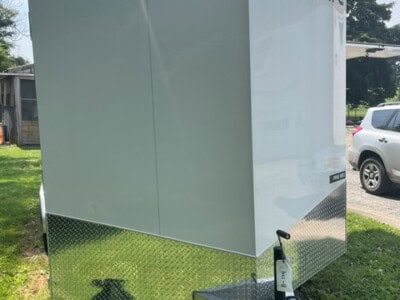 Enclosed aluminum concession trailer with ATC logo and diamond plate lower section.