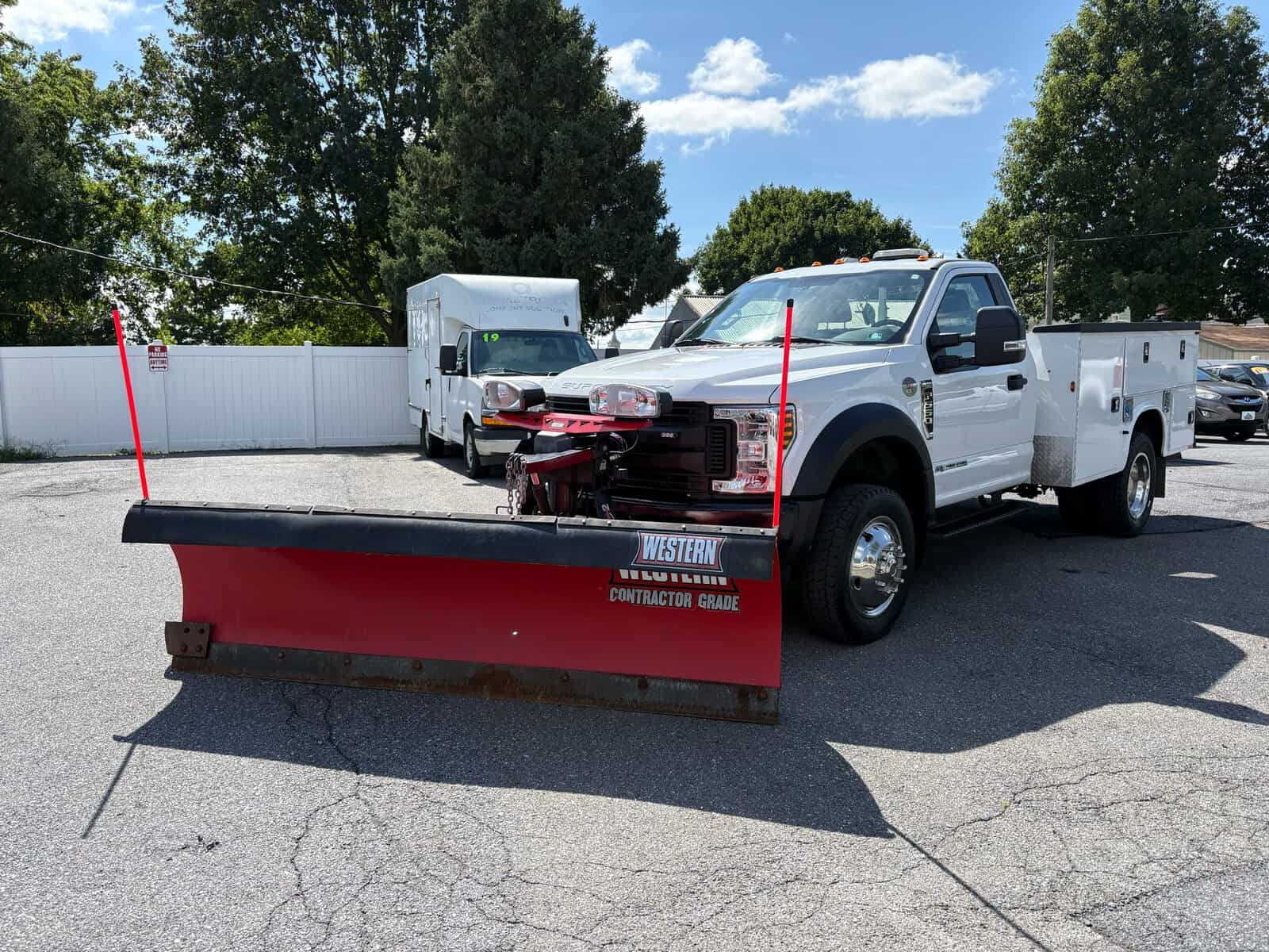 10946 - 2018 Ford F-550 Chassis - 002 2018 Ford F-550 Super Duty XL with snow plow attachment in a parking lot.