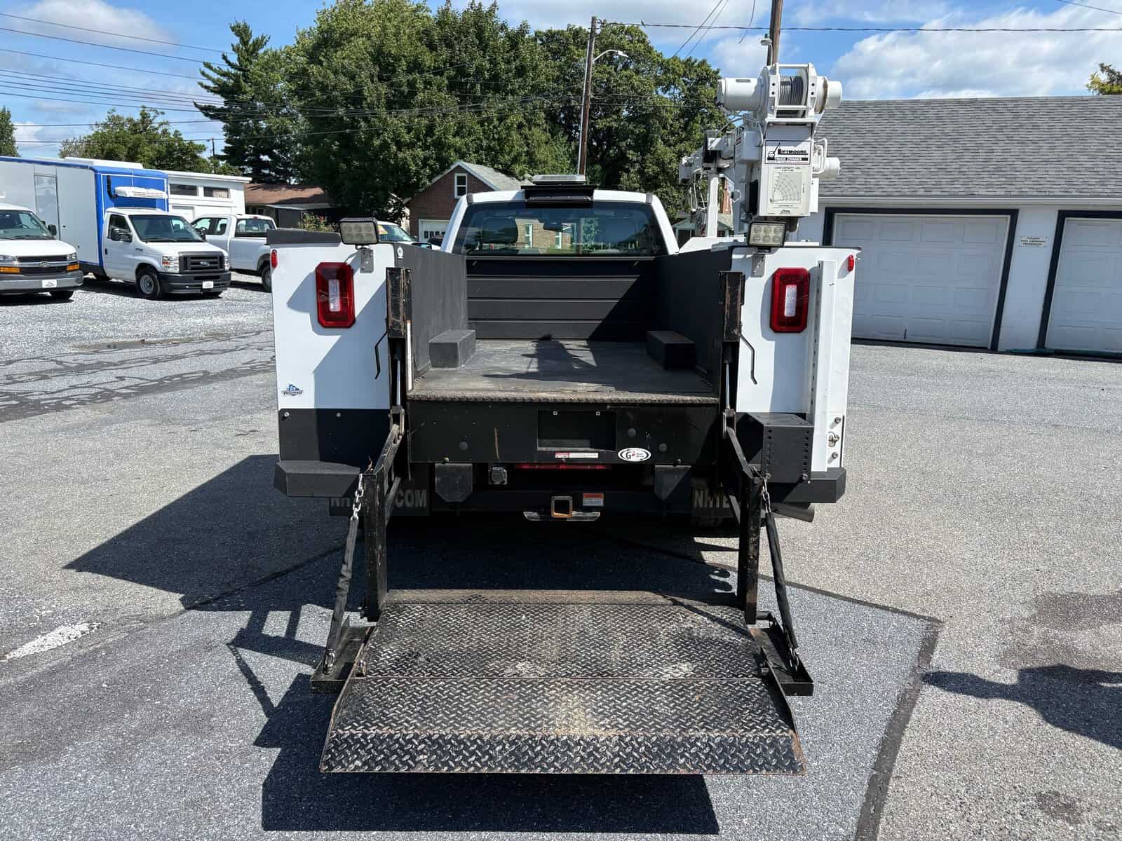 10946 - 2018 Ford F-550 Chassis - 008 White utility truck with lift gate and bucket lift on a paved lot.