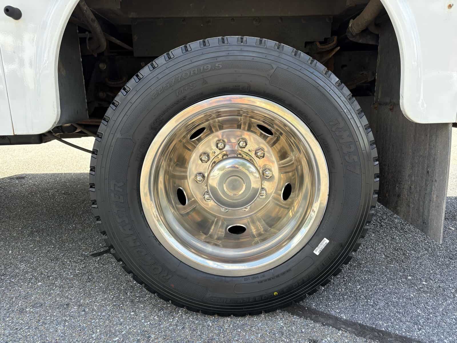 10946 - 2018 Ford F-550 Chassis - 024 Heavy-duty truck tire with chrome rim on a white Ford F-550 Super Duty XL.