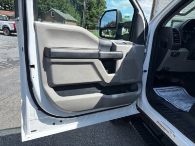 Close-up of the driver side door interior of a white Ford F-550 Super Duty XL.