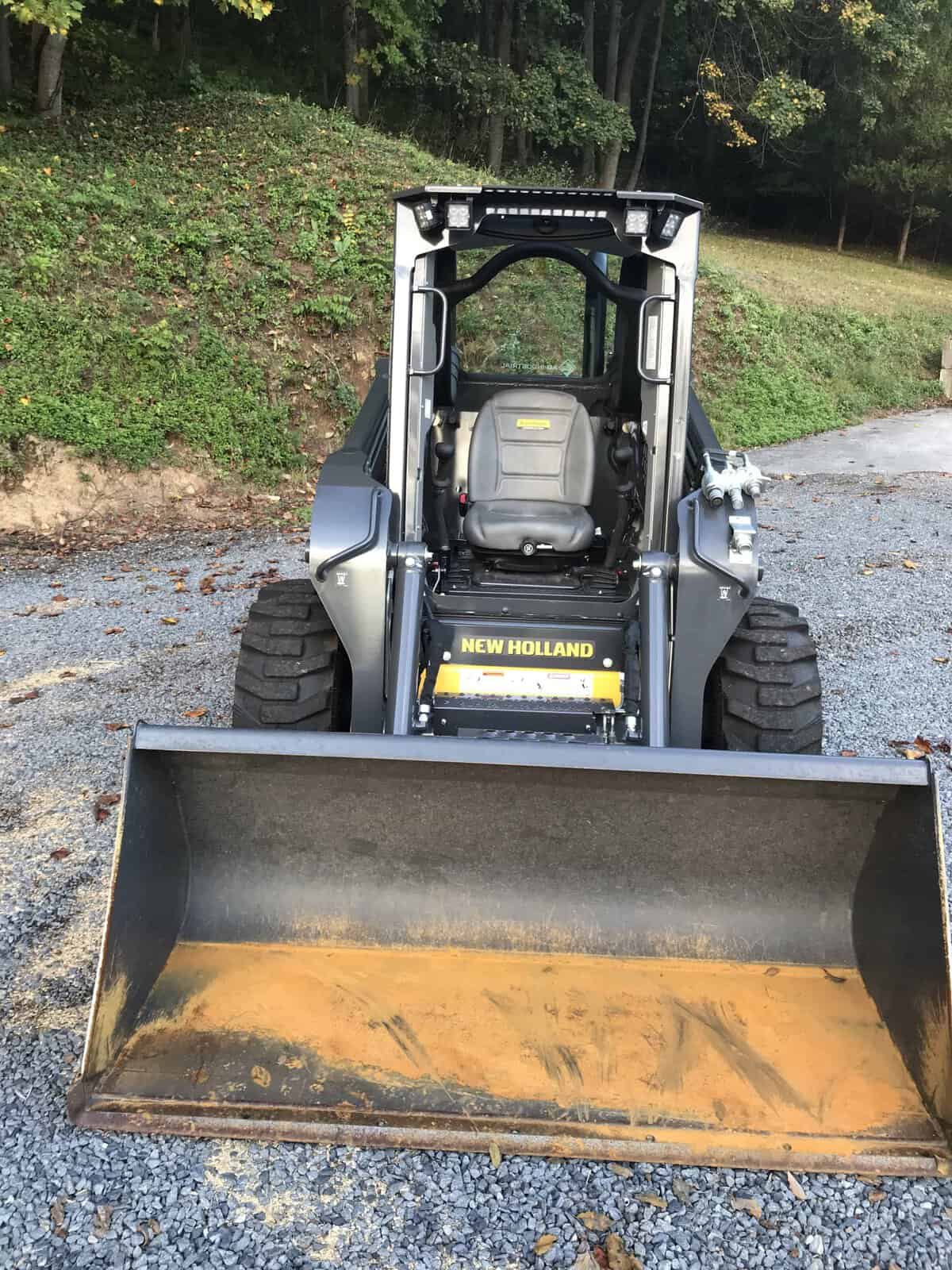 IMG_0743 (1) 2026 New Holland L320 skid steer loader with front bucket attachment on gravel surface.
