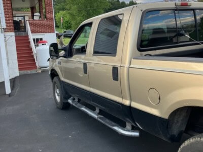 2004 Ford F-250 Super Duty pickup truck with extended cab and running boards.