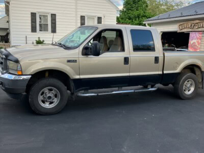 2004 Ford F-250 Super Duty extended cab pickup truck with dual rear wheels and black trim.