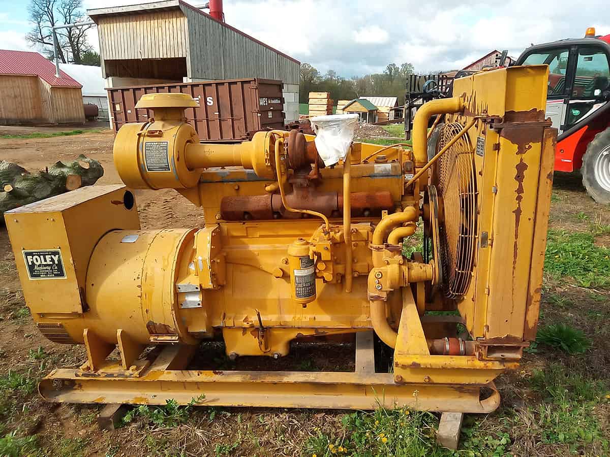 Caterpillar D334 diesel engine with radiator and cooling fan, yellow color, outdoor setting.