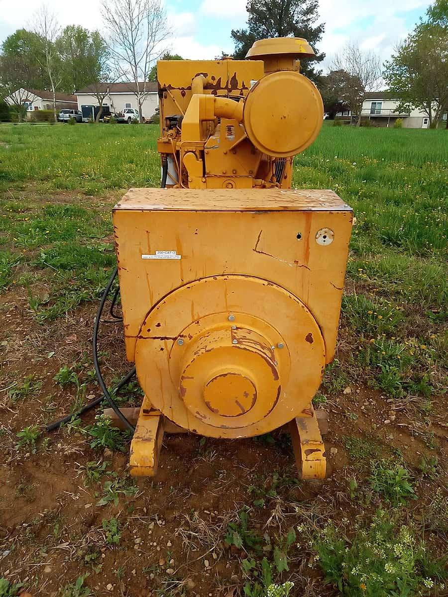 Caterpillar D334 Engine for Heavy Equipment Yellow Caterpillar D334 engine with visible components and controls on a grassy field.