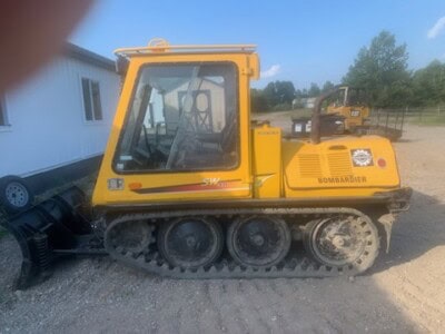 Yellow Bomag BMR 600 compact track loader with enclosed cab and rubber tracks.