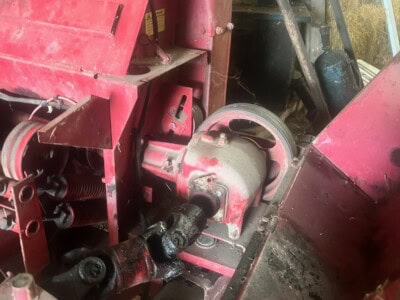Close-up of engine components on a New Holland 782 tractor showing hydraulic and mechanical parts.