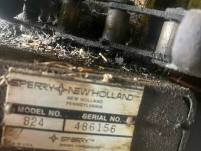 Close-up of Sperry New Holland 824 tractor serial plate with model and serial numbers.