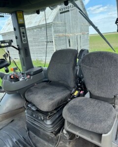 Cab interior of a 2013 Challenger MT855C tractor with dual seats and control panel.