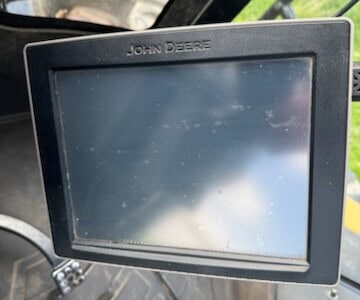 John Deere display monitor inside agricultural machinery cab.