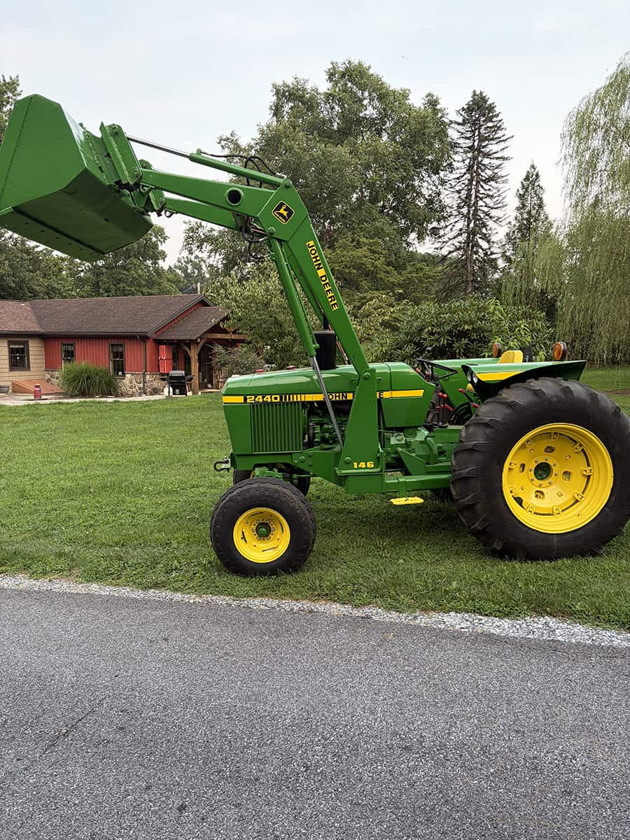 John Deere 2440 Compact Utility Tractor with Front Loader Green John Deere 2440 tractor with front loader and yellow wheels on grassy area.