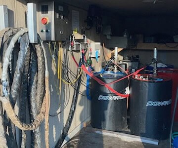 Electrical control panel with hoses and tanks for spray foam insulation system.