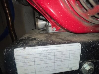 Close-up of hydraulic pump with specifications label for HALEY HLDT spray foam insulation equipment.