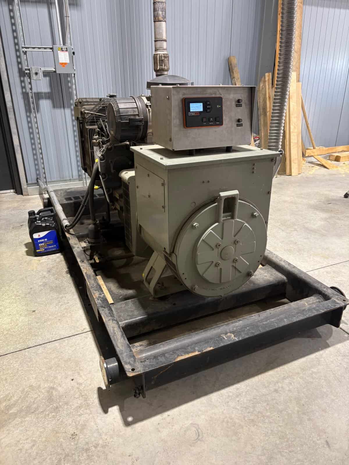Industrial Generator Set with Control Panel Industrial generator set with control panel, mounted on a black metal frame in a warehouse setting.
