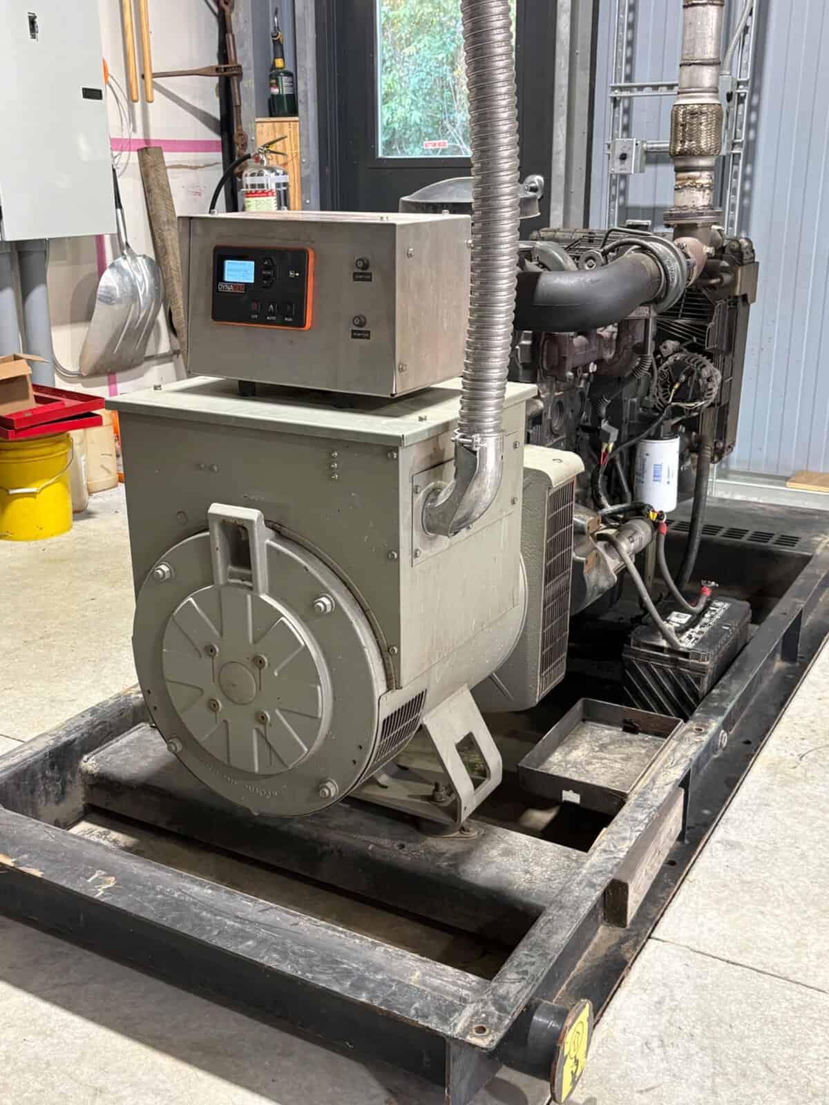 Industrial Generator Set with Control Panel Industrial generator set with control panel and exhaust system in workshop.