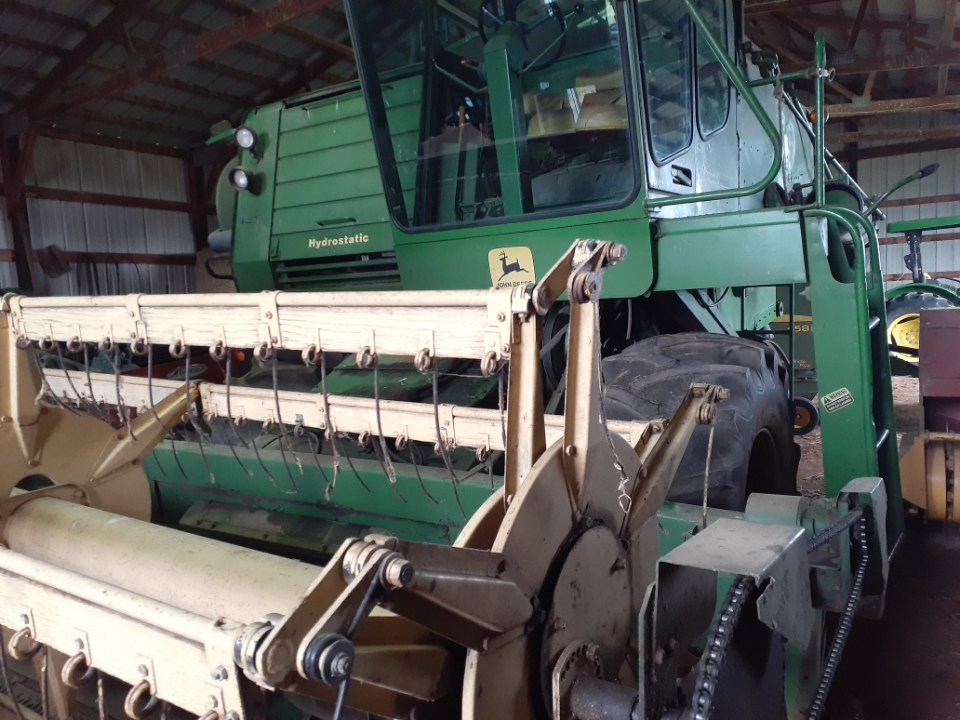 John Deere 6600 Hydrostatic Combine Harvester Green John Deere 6600 hydrostatic combine harvester with large tires and cutting header inside barn.