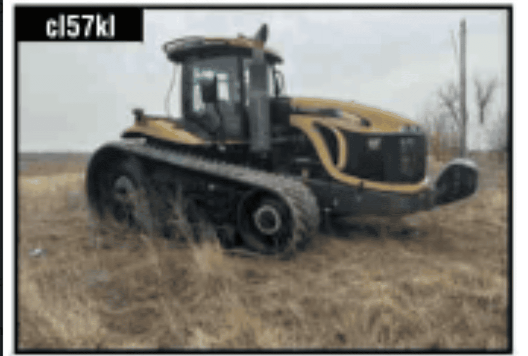 John Deere 8R tractor with tracks and enclosed cab in a field.