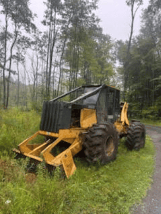 Screenshot 2026-09-09 113543 Yellow and black forestry skid steer loader with grapple attachment on grassy roadside.