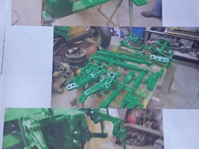 Green agricultural implement frame with hydraulic components and attachment points.