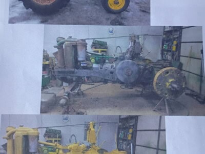 Three vintage John Deere tractors in different colors and conditions.
