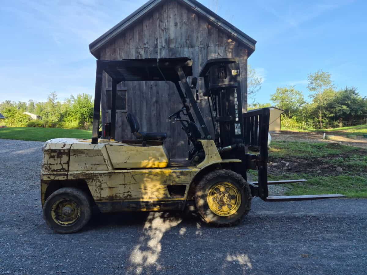 Used forklift with black mast and yellow body, showing signs of wear and rust.