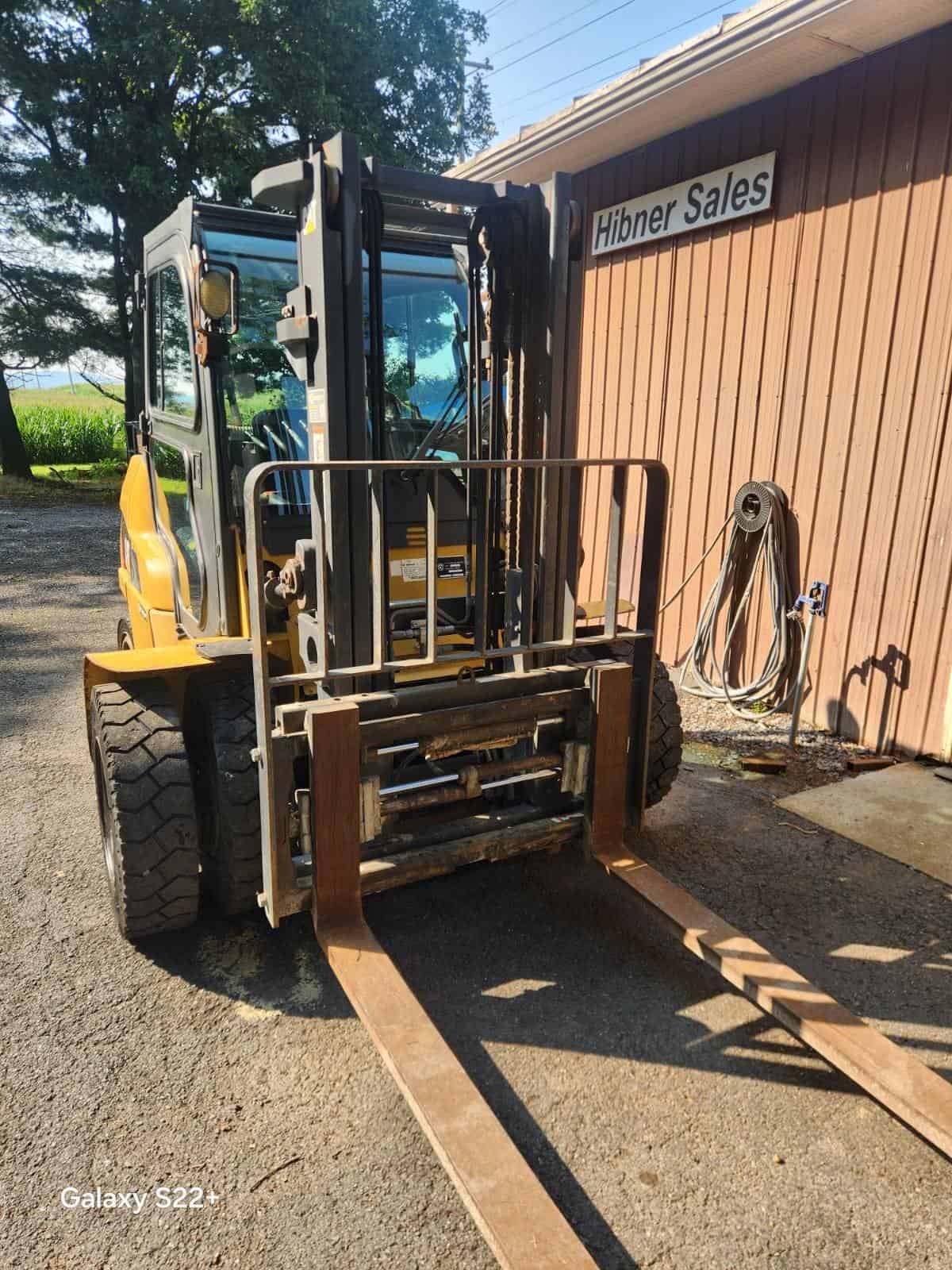 Used Caterpillar Forklift for Sale Yellow Caterpillar forklift with enclosed cab and extended forks at Hibner Sales.