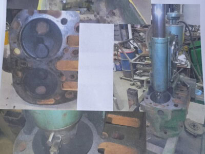 Rebuilding engine motor with visible cylinder head and piston components.