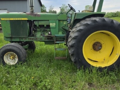 1972 John Deere 4620 tractor with canopy and large rear tires on grassy field.