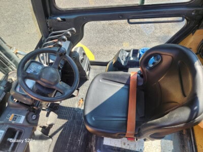 View of the operator's seat and control panel inside a John Deere compact excavator.