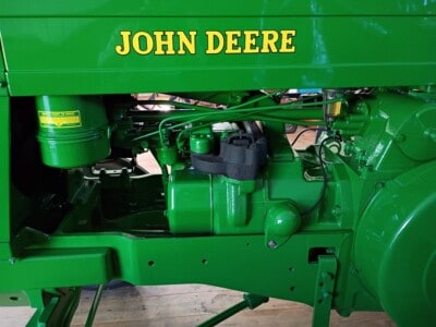 Close-up of green John Deere tractor engine and hydraulic components.