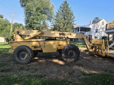 2006 Pettibone T8044 telehandler with extended boom and large tires in a yard.