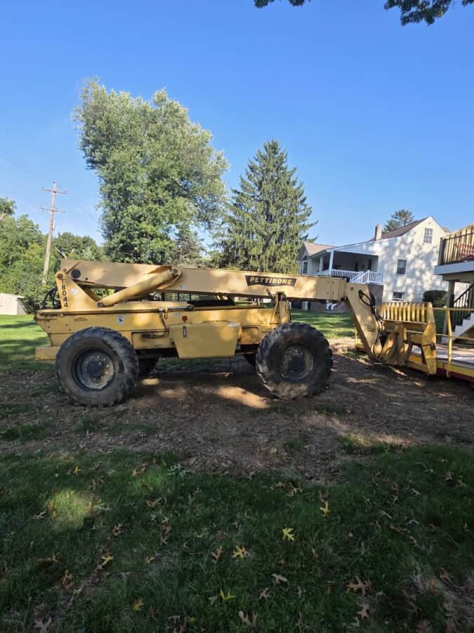 2006 Pettibone T8044 telehandler with extended boom and large tires in a yard.