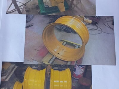 Yellow heavy equipment wheel rims and a green hydraulic component.